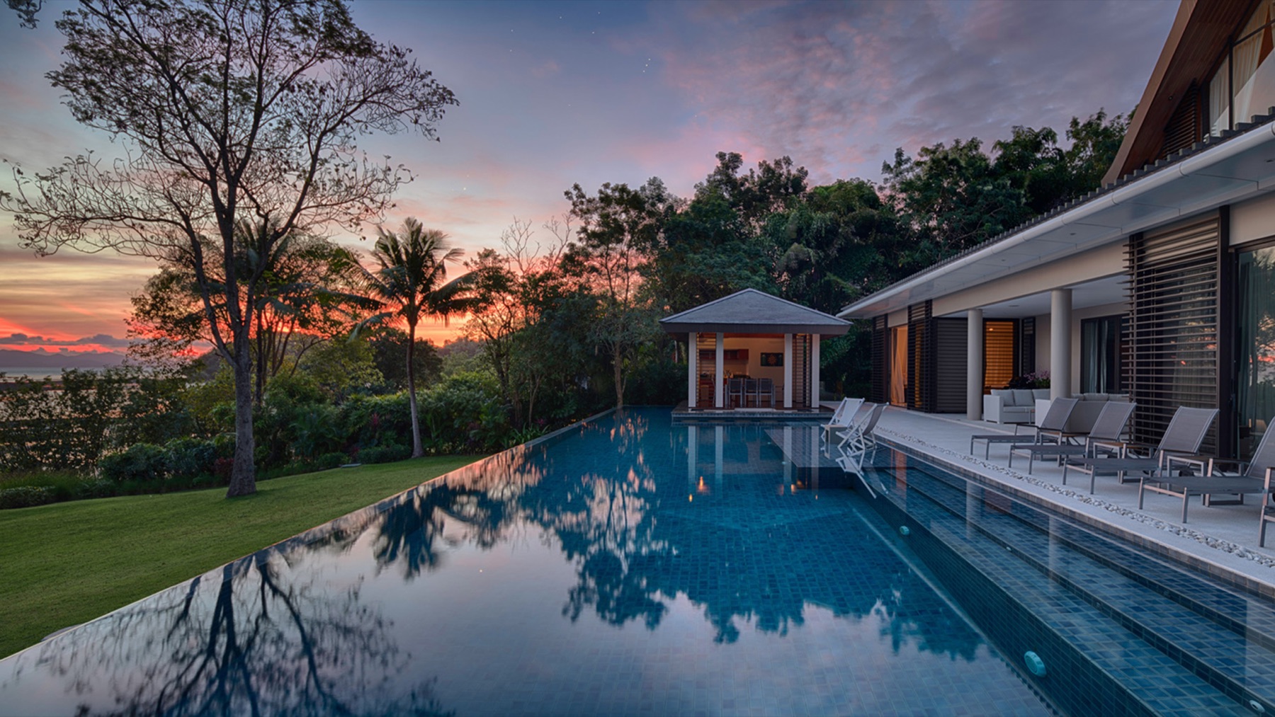 Villa Naam Sawan and its infinity pool at dusk